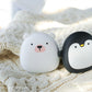 Polar bear and penguin USB Rechargeable Hand Warmers on a knitted blanket, perfect for cozy camping and hiking trips.