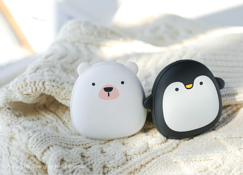 Polar bear and penguin USB Rechargeable Hand Warmers on a knitted blanket, perfect for cozy camping and hiking trips.