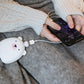 Polar bear USB Rechargeable Hand Warmer charging a smartphone, showcasing dual functionality for outdoor convenience.