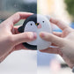 Hands holding USB Rechargeable Hand Warmers shaped like a penguin and polar bear, ideal for outdoor recreation warmth.