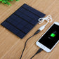 Solar Power Bank Charger 4 in 1 charging dock station charging a smartphone via USB on bamboo mat, ideal for outdoor power needs.